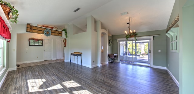 spare room with visible vents, wood finished floors, baseboards, a chandelier, and vaulted ceiling