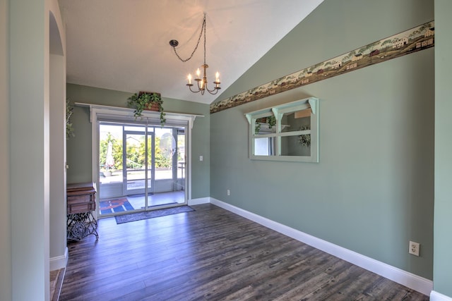 spare room featuring baseboards, lofted ceiling, an inviting chandelier, and dark wood-style flooring