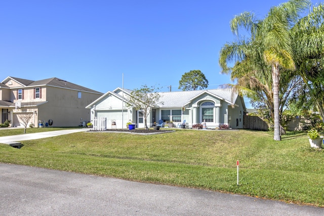 ranch-style home with a front lawn, an attached garage, fence, and driveway