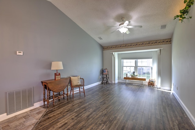 living area with visible vents, a textured ceiling, dark wood-style floors, and ceiling fan