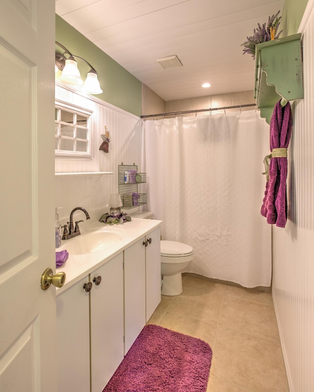 bathroom with tile patterned floors, curtained shower, toilet, and vanity