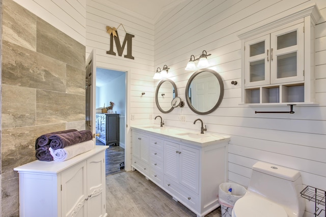 full bath featuring double vanity, toilet, wood finished floors, and a sink