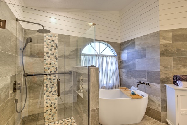 bathroom featuring a soaking tub, tile walls, and a stall shower