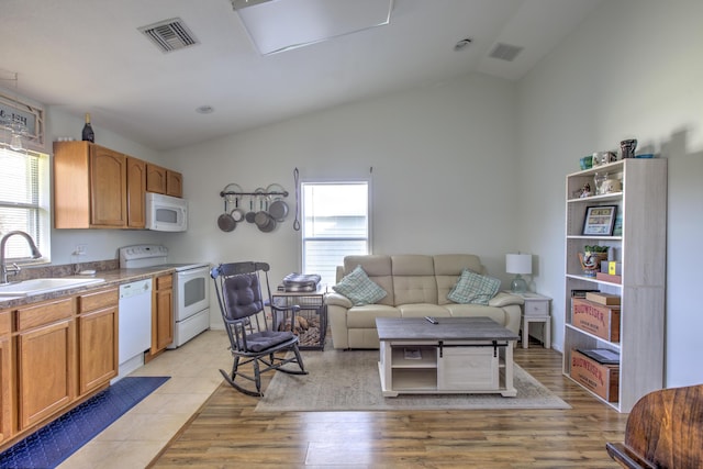 living room featuring visible vents, lofted ceiling, and light wood-style floors