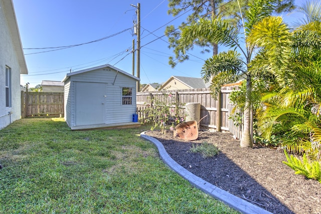 view of yard with an outdoor structure, a fenced backyard, and a shed