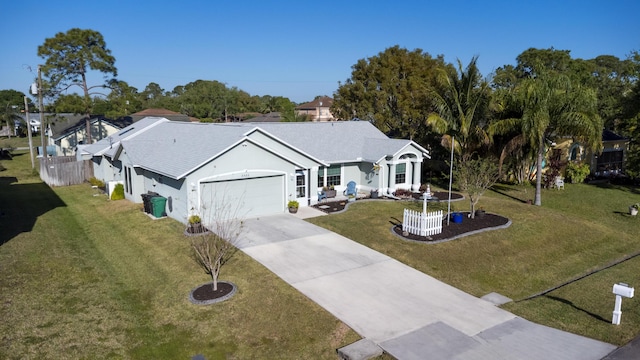 ranch-style home featuring a front yard, an attached garage, fence, and driveway