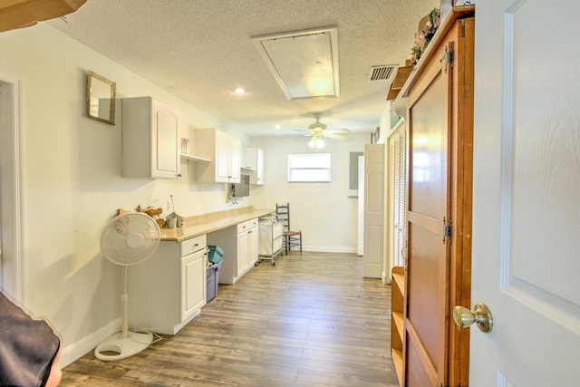 kitchen featuring wood finished floors, ceiling fan, light countertops, white cabinets, and a textured ceiling