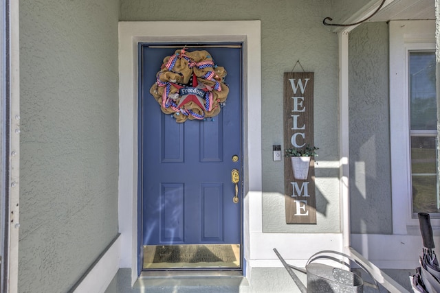 property entrance with stucco siding