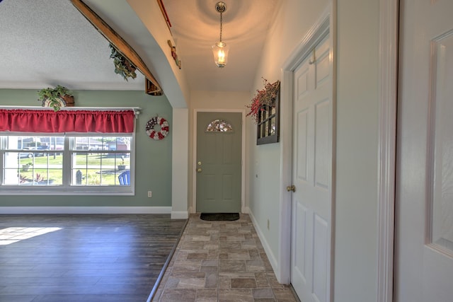 foyer with a textured ceiling and baseboards