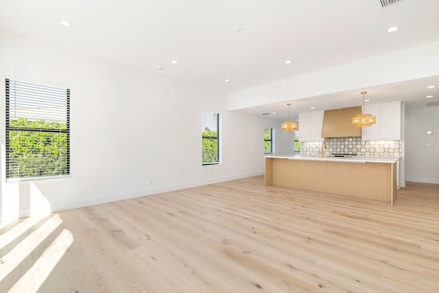unfurnished living room with light wood-type flooring and recessed lighting