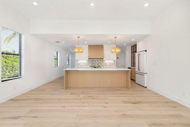 kitchen featuring tasteful backsplash, recessed lighting, custom range hood, light countertops, and high end white fridge
