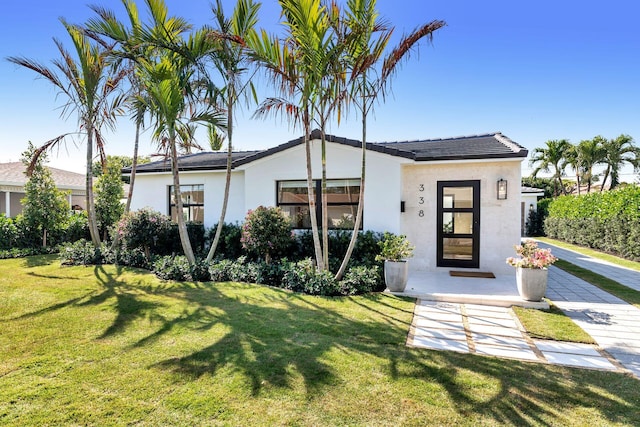 view of front of property featuring a front lawn and stucco siding