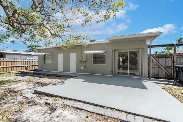 991 SW 31st St, Fort Lauderdale, FL 33315 - back of house with a gate, stucco siding, a patio, and fence