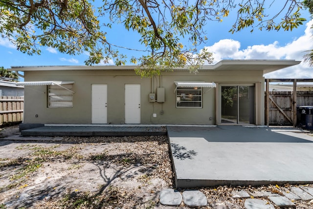 991 SW 31st St, Fort Lauderdale, FL 33315 - rear view of property featuring stucco siding, a patio, and fence