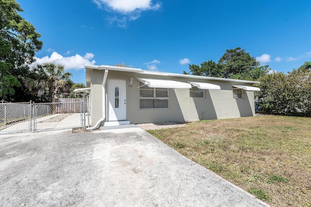 991 SW 31st St, Fort Lauderdale, FL 33315 - ranch-style house with fence, a front lawn, and a gate