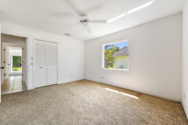 5116 Palm Way, Lake Worth, FL 33463 - unfurnished bedroom with carpet floors, a closet, and a ceiling fan