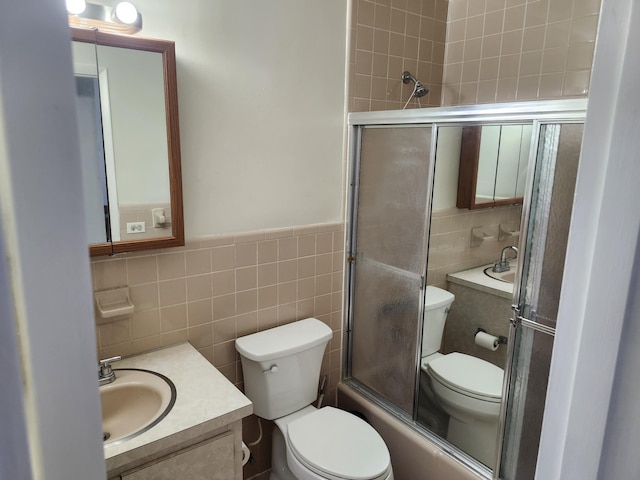 full bathroom featuring vanity, enclosed tub / shower combo, wainscoting, tile walls, and toilet