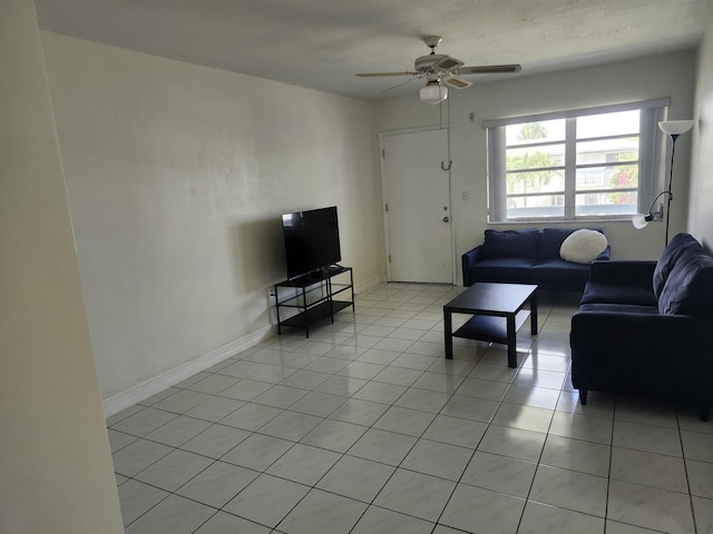 living room featuring light tile patterned flooring, baseboards, and ceiling fan