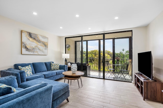 living area with floor to ceiling windows, recessed lighting, and light wood-type flooring