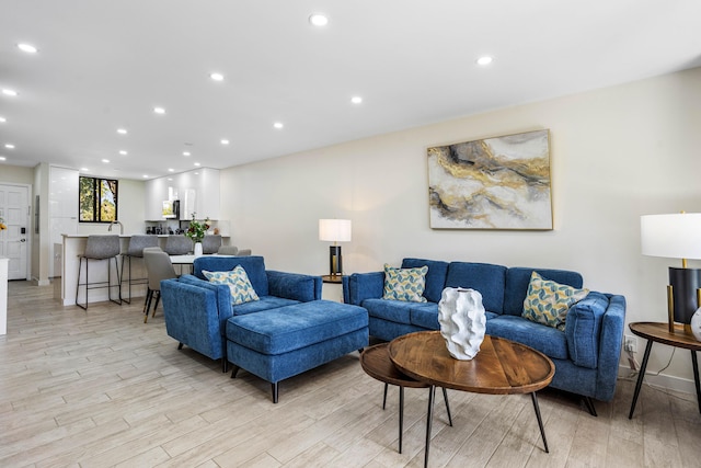 living room with recessed lighting, baseboards, and light wood finished floors