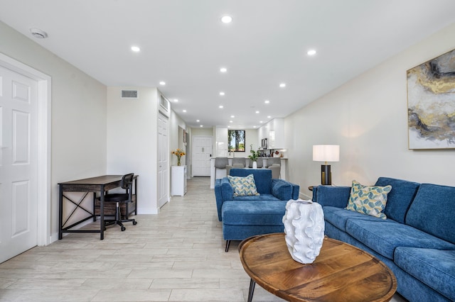 living area featuring recessed lighting, visible vents, light wood-type flooring, and baseboards