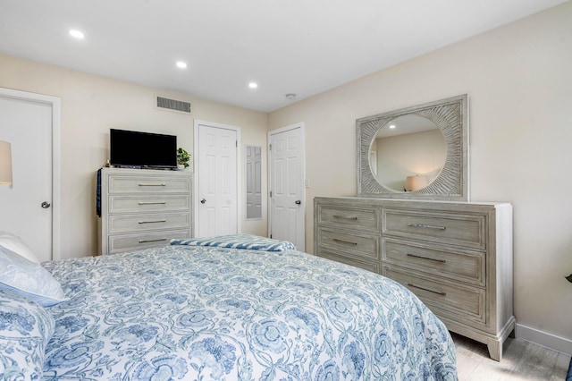 bedroom with light wood-style flooring, recessed lighting, visible vents, and baseboards