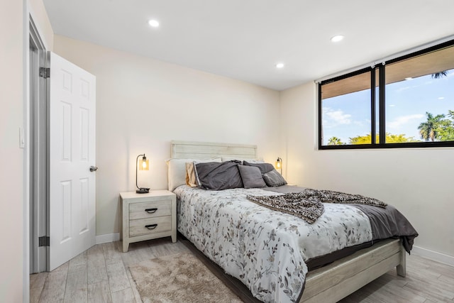 bedroom featuring light wood finished floors, recessed lighting, and baseboards