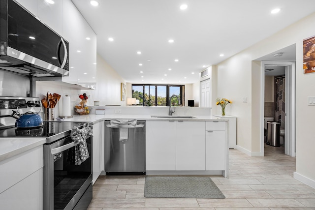kitchen featuring white cabinetry, appliances with stainless steel finishes, modern cabinets, and a sink