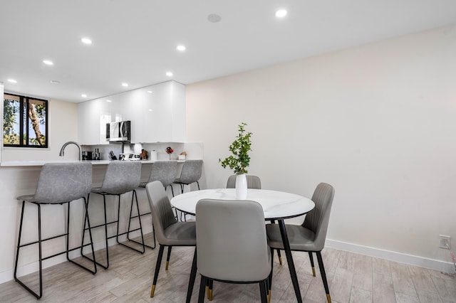 dining space featuring recessed lighting, light wood-type flooring, and baseboards