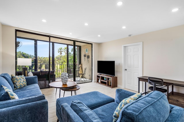 living room featuring light wood finished floors, recessed lighting, baseboards, and expansive windows