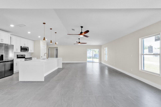 8585 100th Ave, Vero Beach, FL 32967 - kitchen with appliances with stainless steel finishes, a sink, open floor plan, a center island with sink, and baseboards