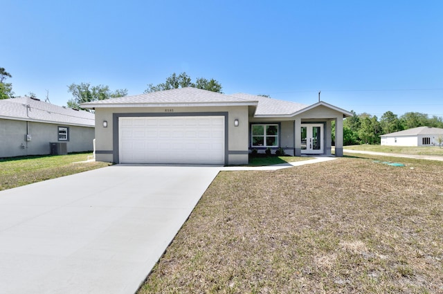 8585 100th Ave, Vero Beach, FL 32967 - ranch-style house with french doors, a garage, concrete driveway, stucco siding, and a front yard
