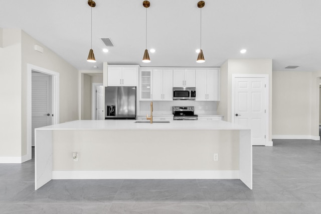 8585 100th Ave, Vero Beach, FL 32967 - kitchen featuring stainless steel appliances, a large island, white cabinetry, glass insert cabinets, and light countertops