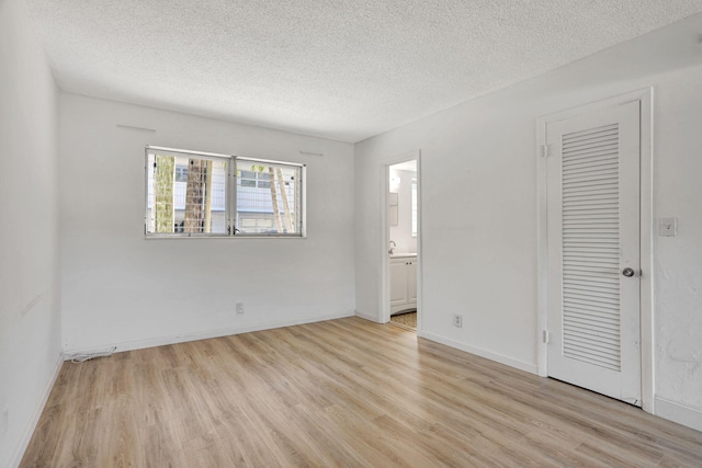 3212 NE 8th Ct Unit 7, Pompano Beach, FL 33062 - unfurnished room featuring light wood finished floors, a textured ceiling, and baseboards