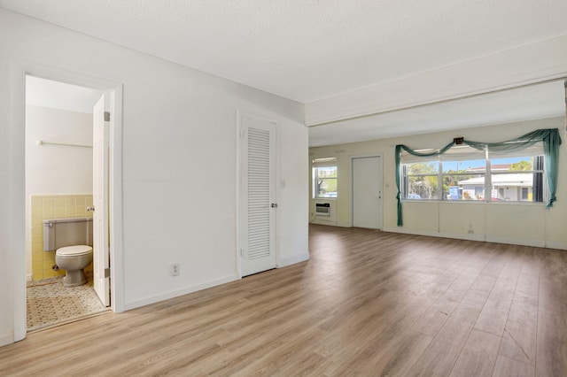 3212 NE 8th Ct Unit 7, Pompano Beach, FL 33062 - empty room featuring wood finished floors, tile walls, and a textured ceiling