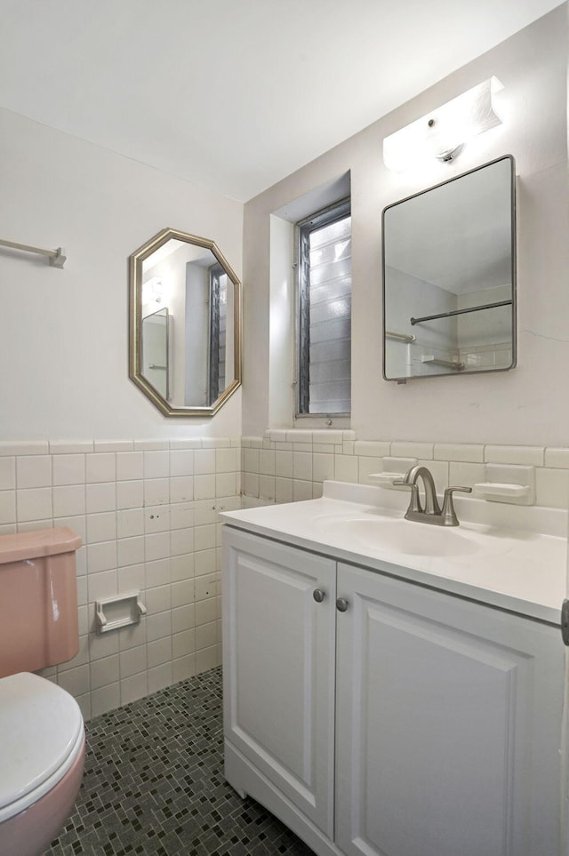 3212 NE 8th Ct Unit 7, Pompano Beach, FL 33062 - bathroom featuring tile walls, toilet, vanity, tile patterned flooring, and a wainscoted wall