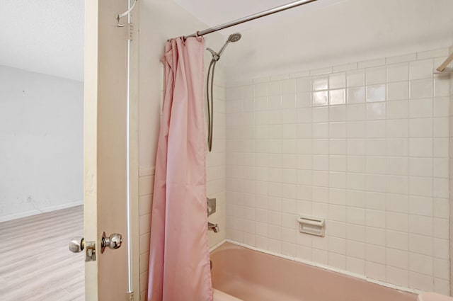 3212 NE 8th Ct Unit 7, Pompano Beach, FL 33062 - bathroom featuring shower / bathtub combination with curtain, wood finished floors, and baseboards