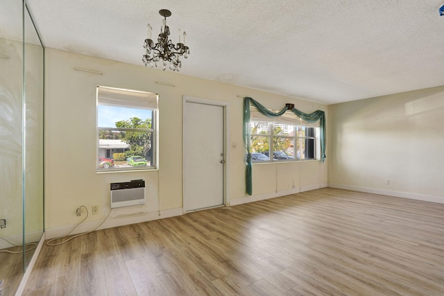 3212 NE 8th Ct Unit 7, Pompano Beach, FL 33062 - foyer entrance featuring wood finished floors, a textured ceiling, an AC wall unit, plenty of natural light, and a chandelier