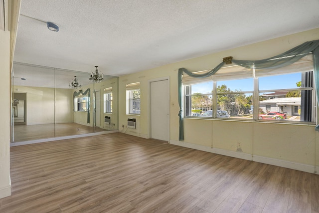 3212 NE 8th Ct Unit 7, Pompano Beach, FL 33062 - spare room featuring wood finished floors, a chandelier, a textured ceiling, and baseboards