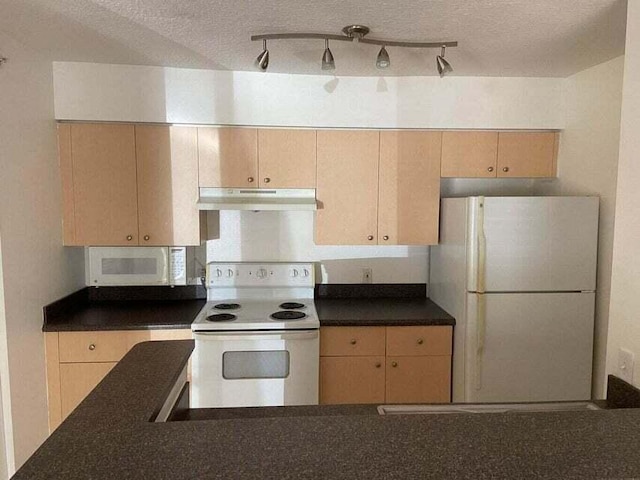 kitchen with light brown cabinets, under cabinet range hood, dark countertops, a textured ceiling, and white appliances