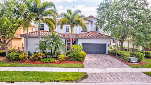 3434 Vanderbilt Dr, Wellington, FL 33414 - mediterranean / spanish house with stucco siding, decorative driveway, an attached garage, and a tile roof