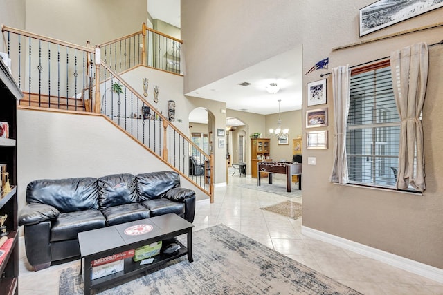 3434 Vanderbilt Dr, Wellington, FL 33414 - tiled living area featuring baseboards, stairway, a high ceiling, an inviting chandelier, and arched walkways