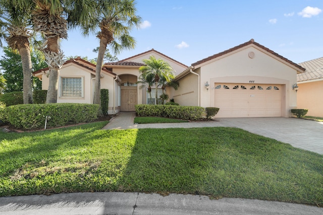 mediterranean / spanish-style home with a tiled roof, decorative driveway, a garage, a front yard, and stucco siding