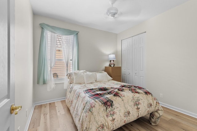 bedroom featuring baseboards, a closet, wood finished floors, and a ceiling fan