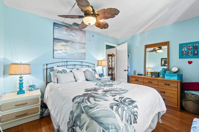 bedroom with a textured ceiling, ceiling fan, and wood finished floors