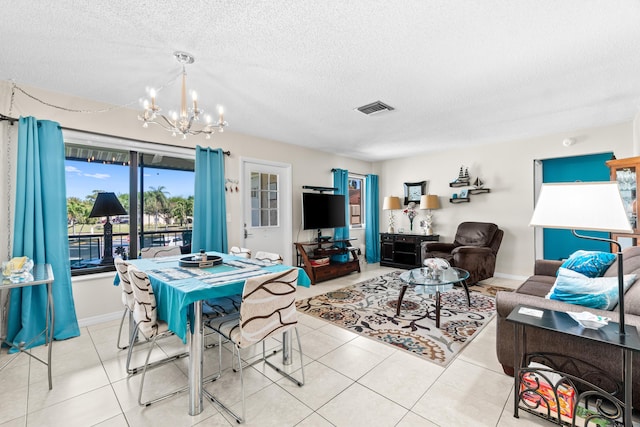 tiled dining space with visible vents, baseboards, a textured ceiling, and a chandelier