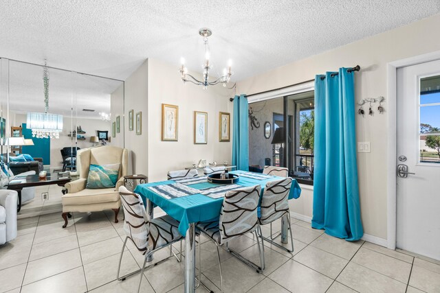 dining space with an inviting chandelier, light tile patterned flooring, and a textured ceiling