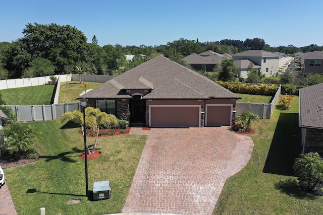 5561 1st Sq SW, Vero Beach, FL 32968 - view of front of house featuring driveway, an attached garage, fence, and a front yard