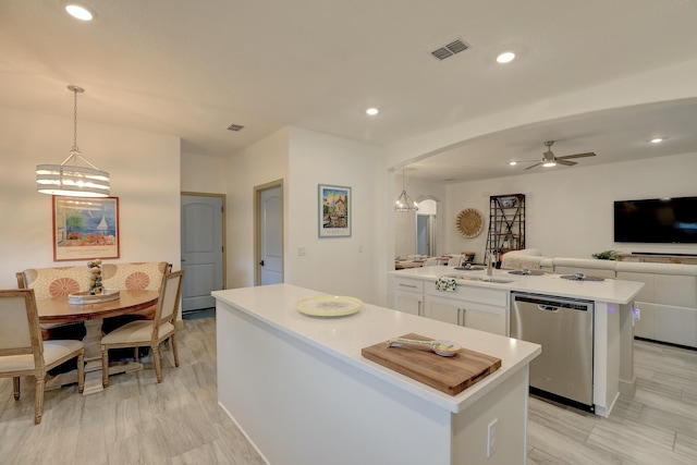 5561 1st Sq SW, Vero Beach, FL 32968 - kitchen featuring open floor plan, a ceiling fan, stainless steel dishwasher, a center island with sink, and white cabinets