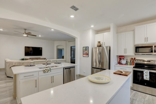 5561 1st Sq SW, Vero Beach, FL 32968 - kitchen with a sink, arched walkways, visible vents, white cabinets, and appliances with stainless steel finishes